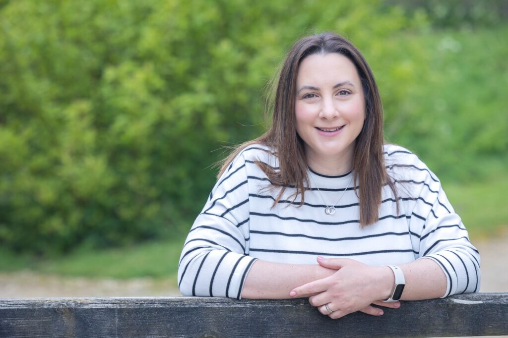 Faye leaning on a fence